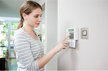 Woman entering security code on keypad.