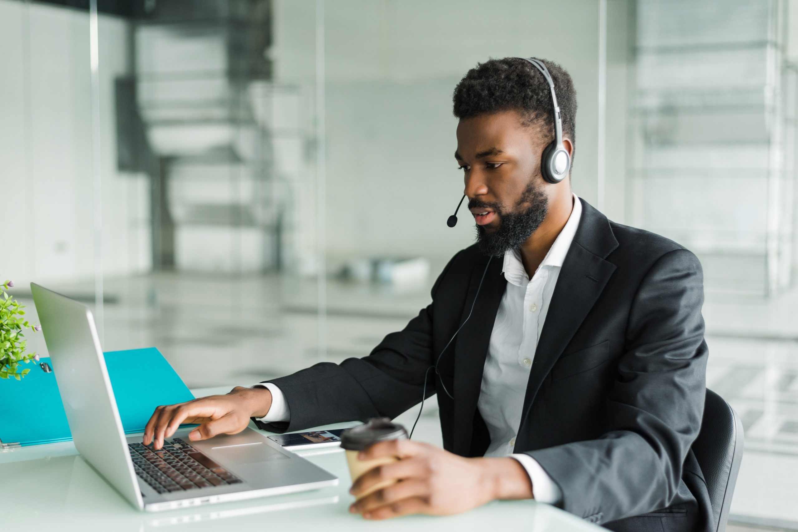 Businessman using laptop and headset.