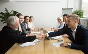 Businessmen shaking hands at meeting.