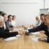 Businessmen shaking hands at meeting.
