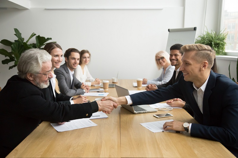 Businessmen shaking hands at meeting.